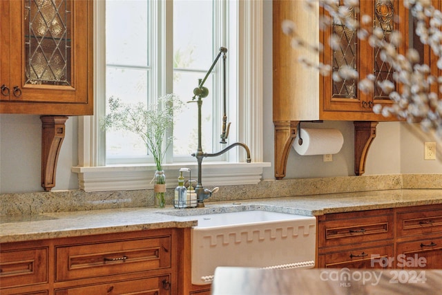 kitchen featuring light stone countertops and sink