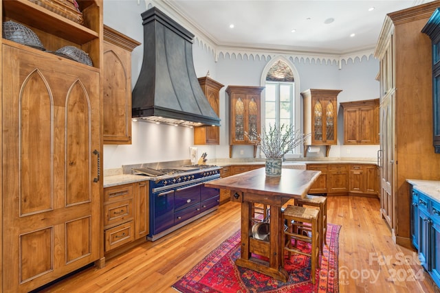 kitchen featuring light hardwood / wood-style flooring, ornamental molding, premium range hood, and double oven range