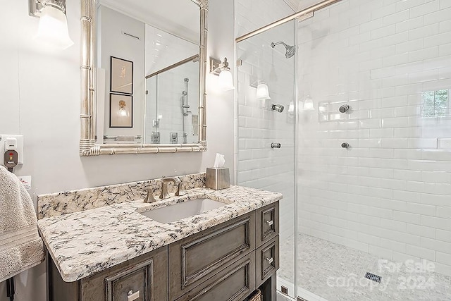 bathroom with vanity and a shower with shower door