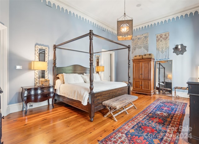 bedroom with crown molding and light hardwood / wood-style flooring