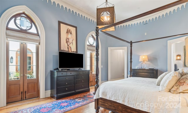 bedroom featuring light wood-type flooring, french doors, and ornamental molding