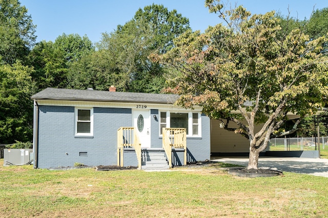 view of front of home with central air condition unit and a front lawn