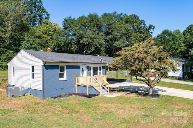 view of front facade with central AC unit and a front yard