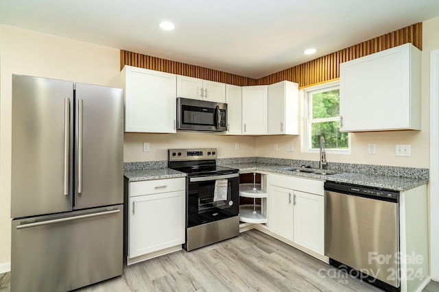 kitchen featuring sink, stainless steel appliances, white cabinets, and light hardwood / wood-style flooring