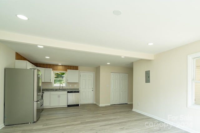 kitchen featuring appliances with stainless steel finishes, light hardwood / wood-style floors, white cabinetry, and sink