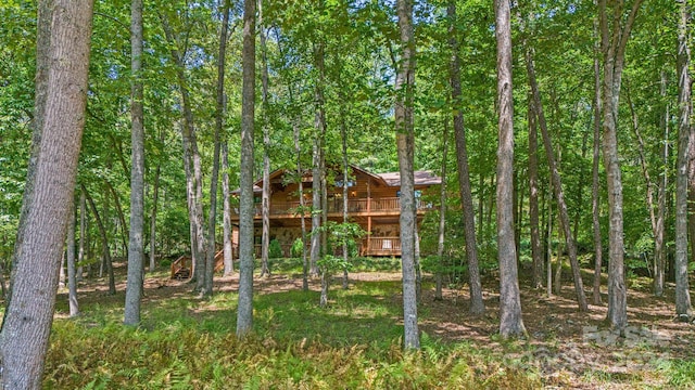 exterior space with a forest view and a deck