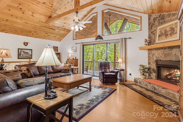 living area featuring a stone fireplace, high vaulted ceiling, wood ceiling, and wood finished floors