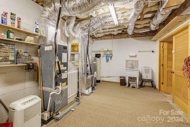 unfinished below grade area featuring concrete block wall, heating unit, and carpet