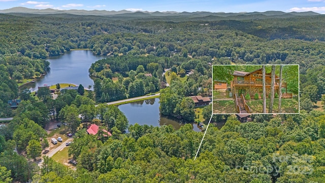 aerial view of property and surrounding area with a heavily wooded area, a nearby body of water, and property parcel outlined