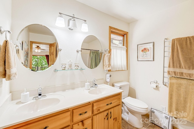 bathroom with toilet, double vanity, tile patterned floors, a ceiling fan, and a shower with curtain