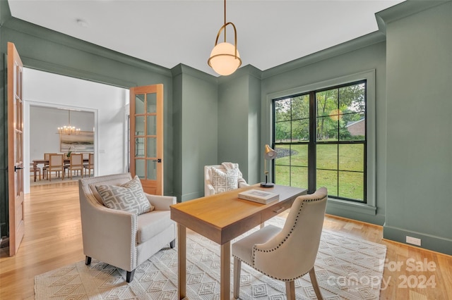 office featuring ornamental molding, a notable chandelier, and light hardwood / wood-style floors