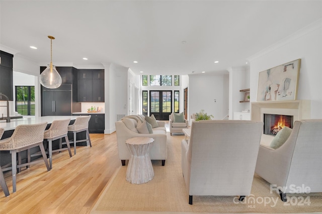 living room with ornamental molding, light hardwood / wood-style floors, and a healthy amount of sunlight