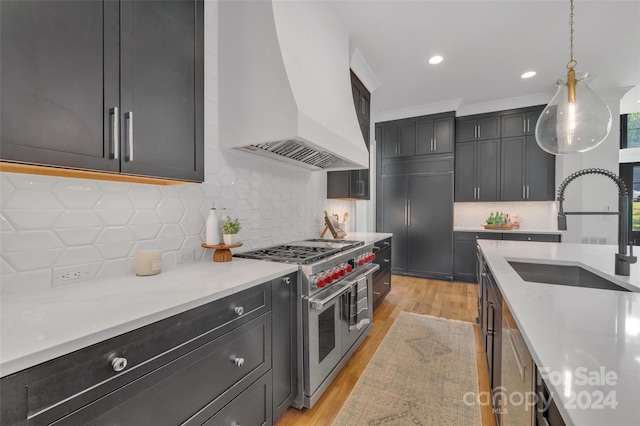 kitchen featuring custom range hood, hanging light fixtures, decorative backsplash, and range with two ovens