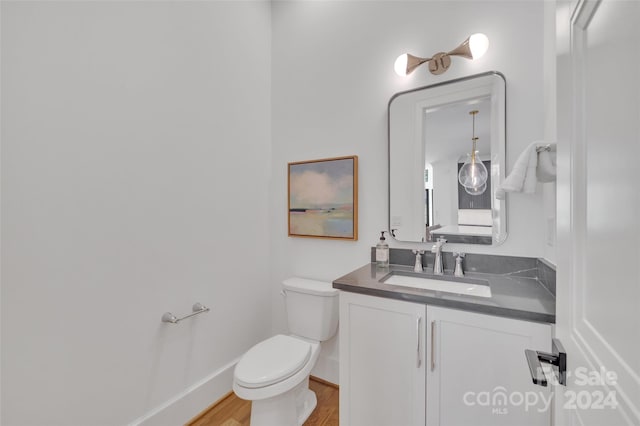 bathroom with vanity, toilet, and hardwood / wood-style flooring