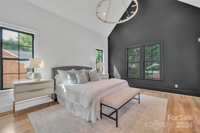 bedroom featuring wood-type flooring and high vaulted ceiling