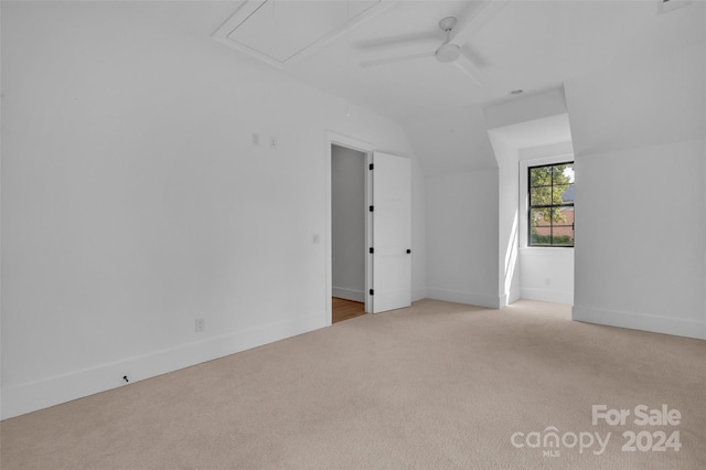 carpeted spare room with vaulted ceiling and ceiling fan