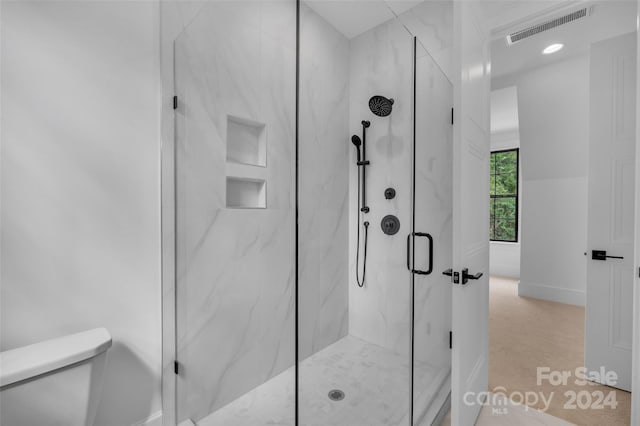 bathroom with walk in shower and toilet