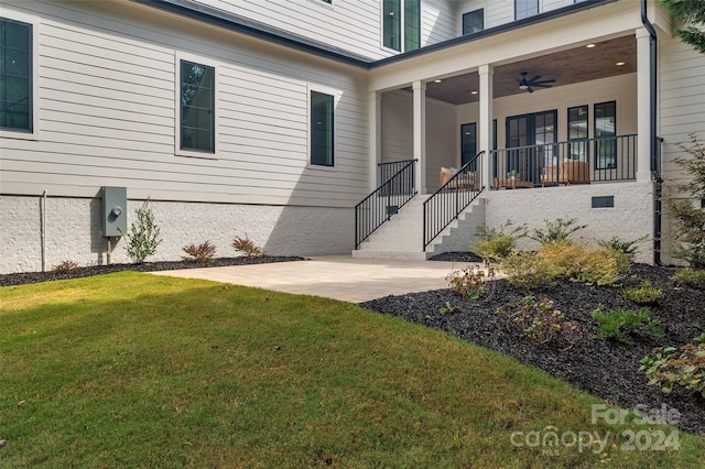 doorway to property featuring ceiling fan and a yard