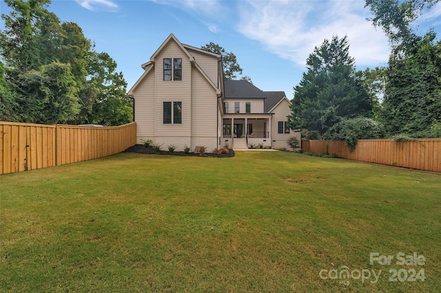 rear view of house featuring a yard