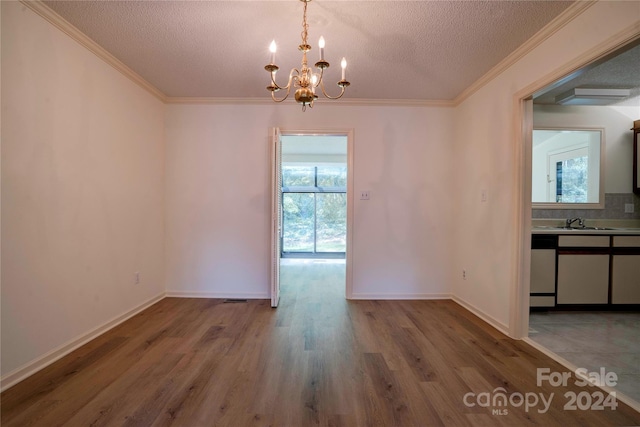 unfurnished dining area featuring a wealth of natural light, an inviting chandelier, hardwood / wood-style flooring, and a textured ceiling