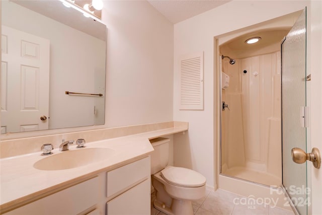 bathroom featuring toilet, tile patterned floors, vanity, a textured ceiling, and a shower