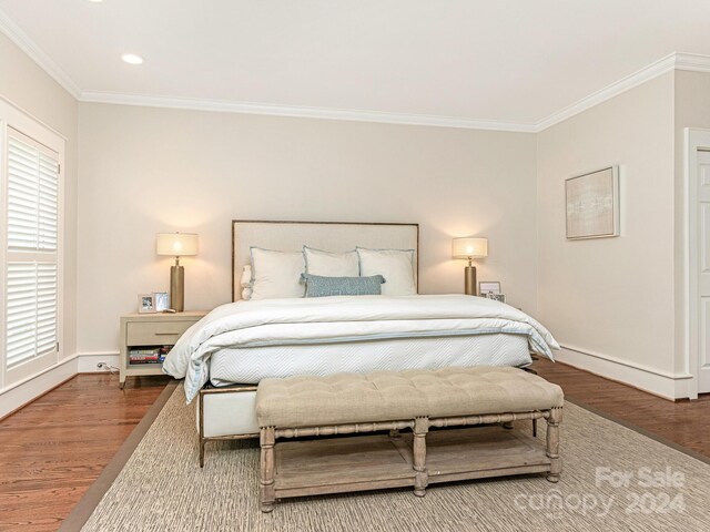 bedroom with ornamental molding and hardwood / wood-style flooring