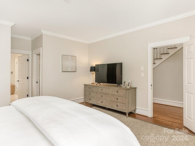 bedroom featuring crown molding and hardwood / wood-style flooring