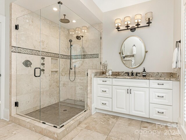 bathroom featuring vanity, an enclosed shower, and tile patterned floors