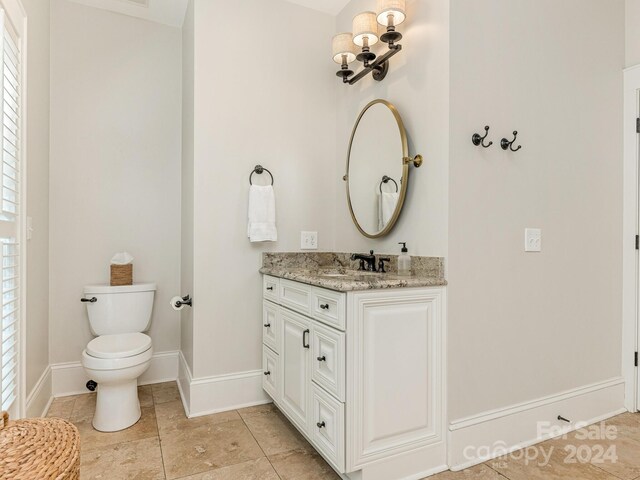 bathroom with vanity, toilet, and tile patterned floors