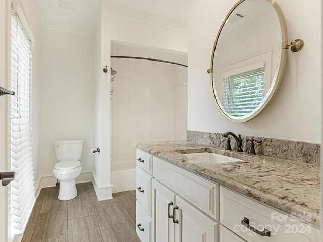 full bathroom featuring vanity, toilet, ornamental molding, and tiled shower / bath combo