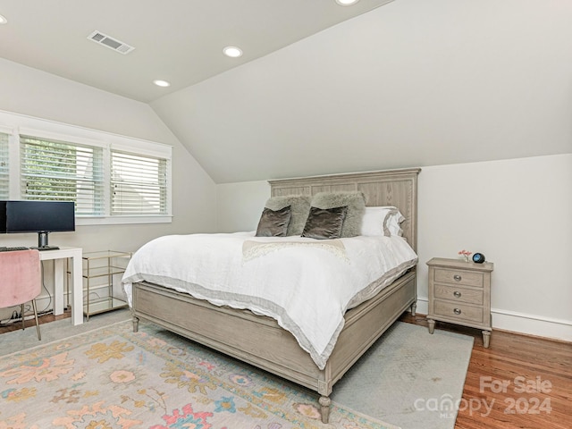 bedroom with vaulted ceiling and light hardwood / wood-style floors