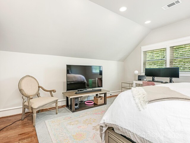 bedroom with light wood-type flooring and lofted ceiling