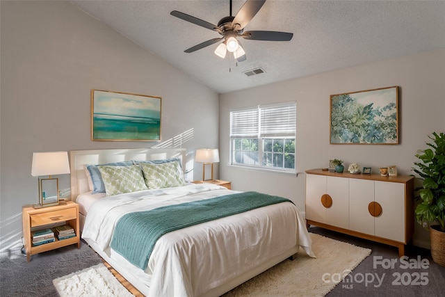 bedroom with visible vents, lofted ceiling, a textured ceiling, and ceiling fan