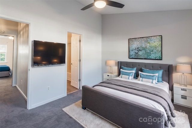 carpeted bedroom with ensuite bath, ceiling fan, baseboards, and lofted ceiling