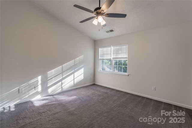 spare room with visible vents, a textured ceiling, baseboards, and dark colored carpet