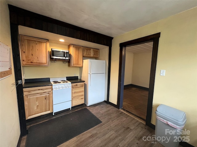 kitchen featuring white appliances and dark hardwood / wood-style floors