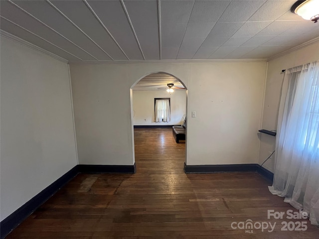 corridor featuring dark wood-type flooring, plenty of natural light, and crown molding