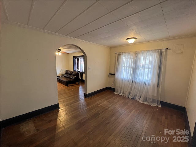 unfurnished room featuring a wealth of natural light, dark hardwood / wood-style floors, and ornamental molding