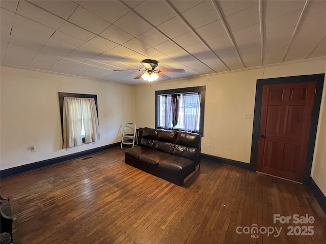 living room featuring ceiling fan, dark hardwood / wood-style floors, and crown molding