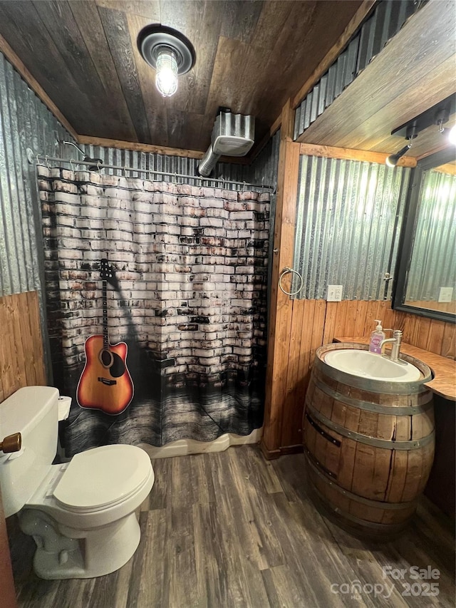 bathroom featuring toilet, vanity, wood-type flooring, wooden walls, and wood ceiling