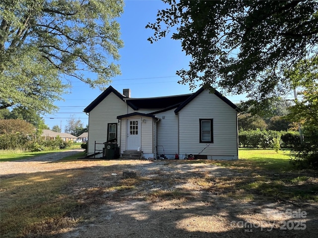 rear view of house featuring a yard