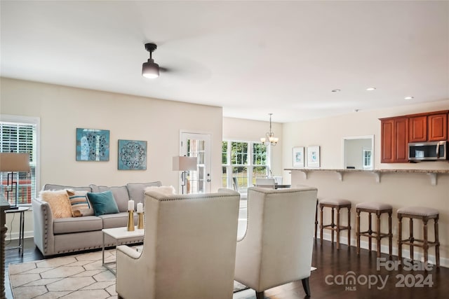 dining area featuring ceiling fan with notable chandelier and wood-type flooring