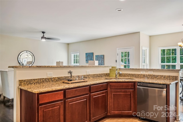 kitchen featuring dishwasher, ceiling fan, sink, and light stone countertops