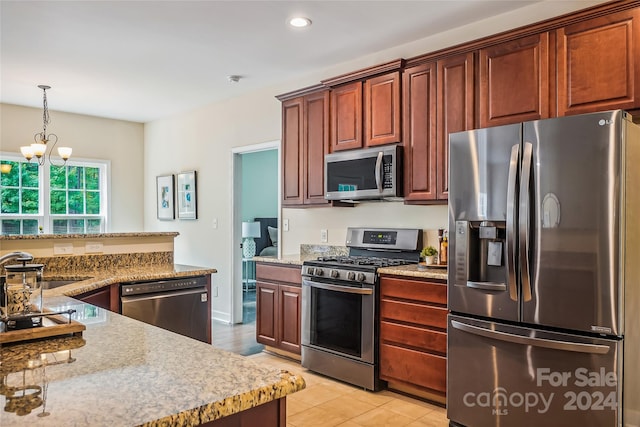 kitchen featuring appliances with stainless steel finishes, light tile patterned floors, an inviting chandelier, and pendant lighting