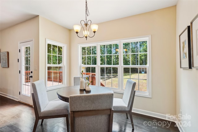 dining space with a wealth of natural light, an inviting chandelier, and dark hardwood / wood-style flooring