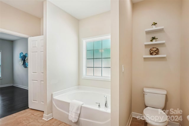 bathroom with toilet, a bathtub, and hardwood / wood-style flooring