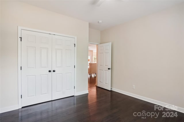 unfurnished bedroom featuring a closet, ceiling fan, and dark hardwood / wood-style floors