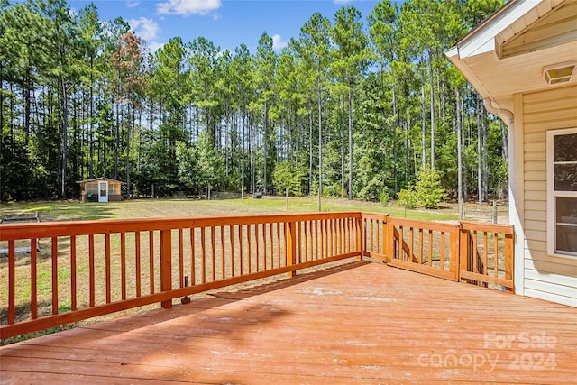 deck featuring a storage shed and a lawn