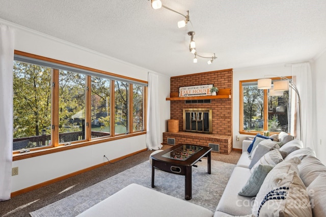 living room with a brick fireplace, a wealth of natural light, a textured ceiling, and carpet floors