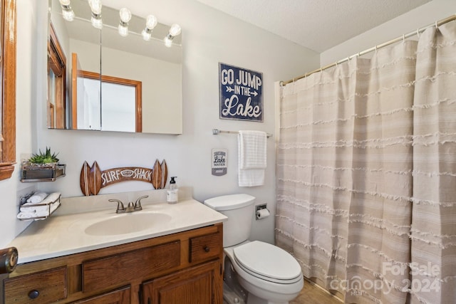 bathroom featuring toilet, vanity, a textured ceiling, and curtained shower